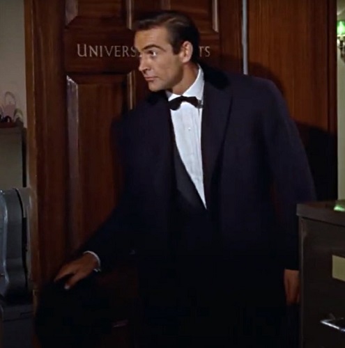 Sean Connery's Bond arrives at Universal Exports wearing his dark navy Chesterfield coat in Dr. No.